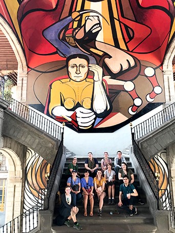 Students on staircase in front of giant mural