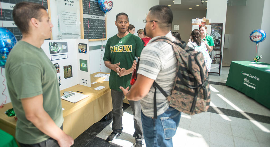 Students chat at a poster presentation at Mason's Engineering School